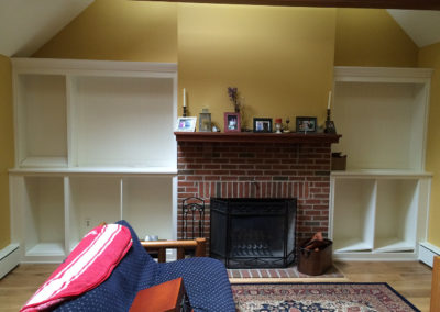 Custom built in remodel shelving surrounding a brick fireplace by Moorestown NJ construction company
