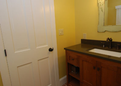 Powder room vanity tucked in next to the door.