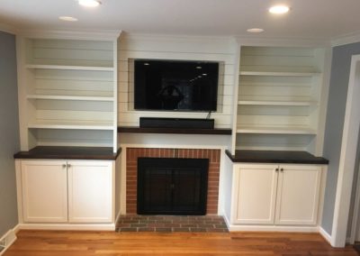 Custom Built-in Cabinets and Bookshelves surrounding a fireplace with media center