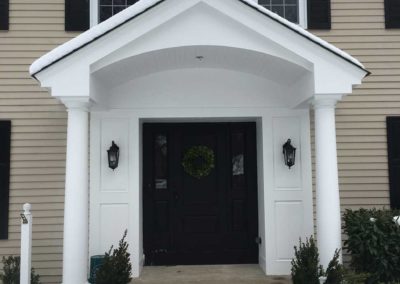 Adding front entryway porch roof to this home adds charm