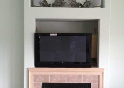Custom wall niche above fireplace for TV media center